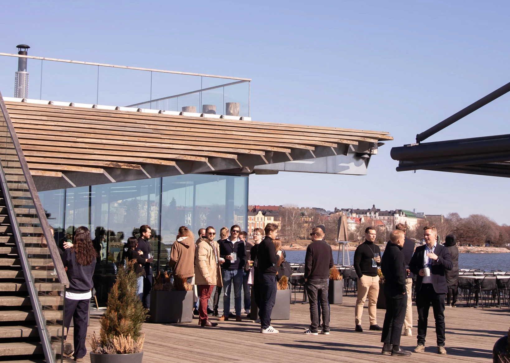 Summit guests connecting on Löyly's waterfront terrace